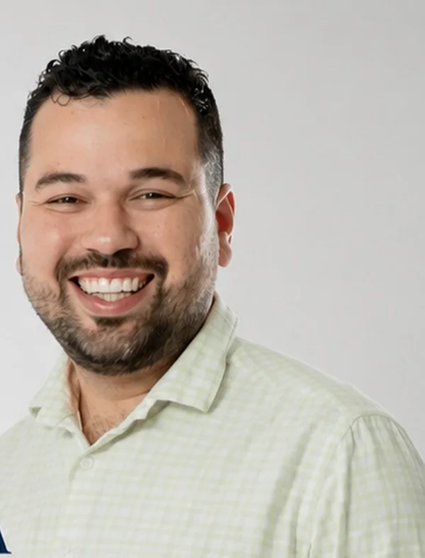Vitor Goese sorrindo, de camisa xadrez clara